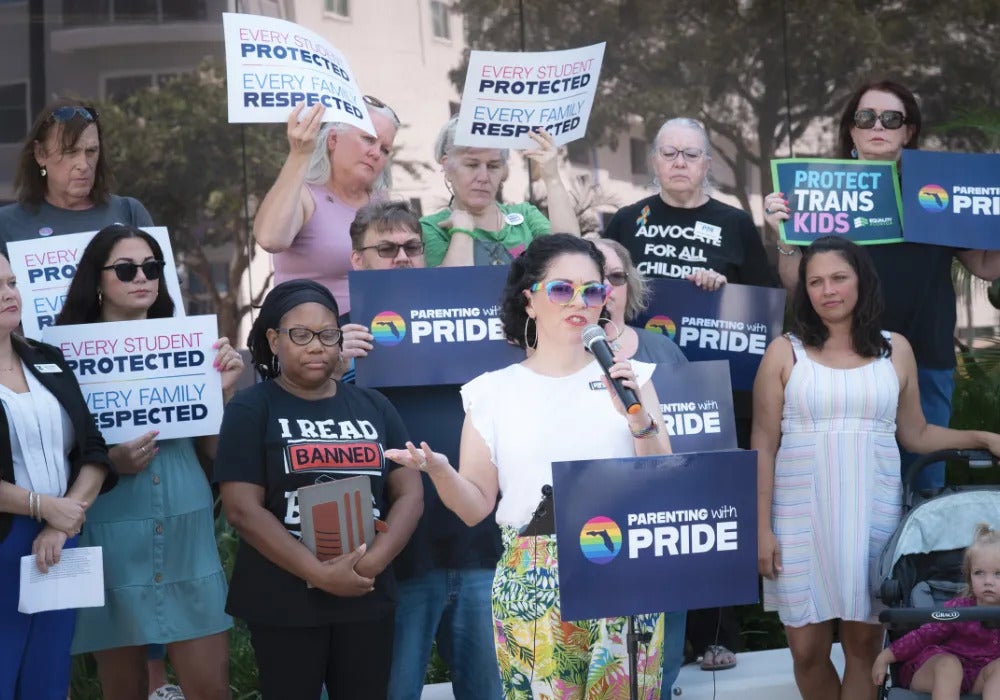 A group of people of all ages holding up signs advocating for gay and transgender rights
