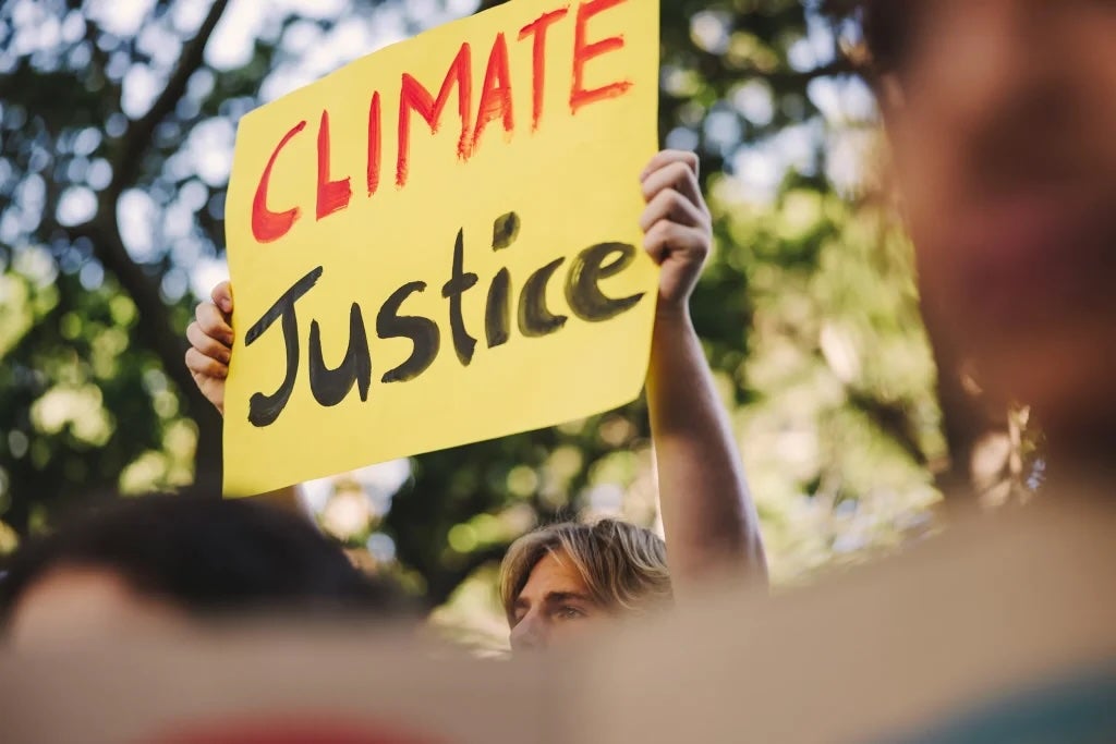A person holding up a sign saying "CLIMATE Justice"