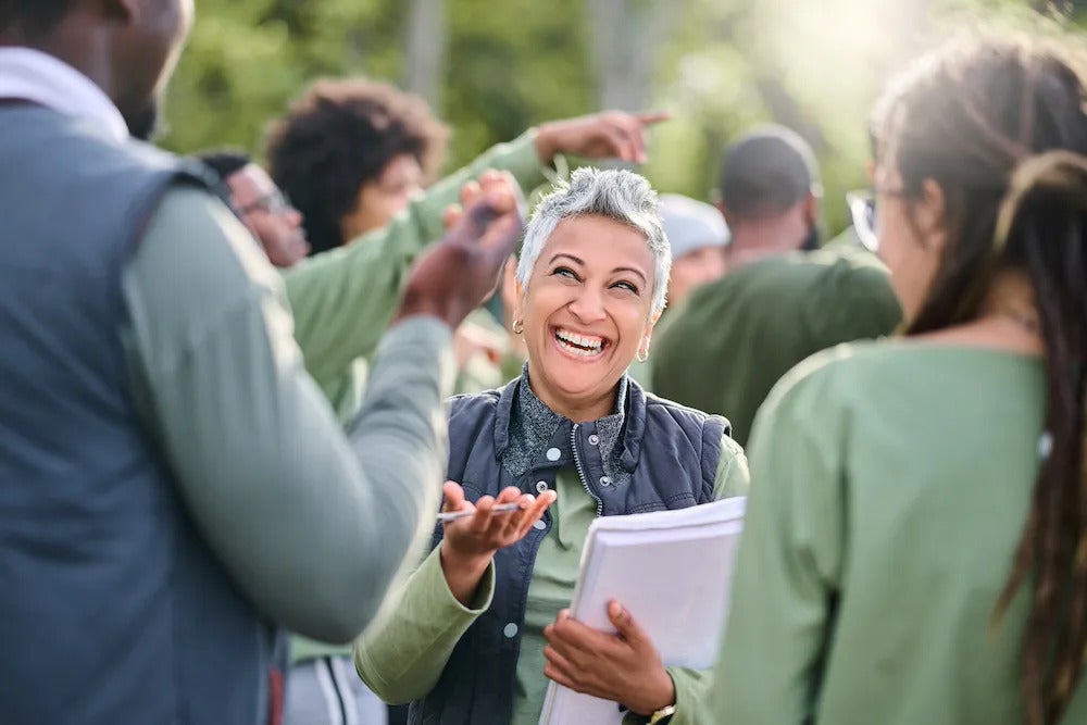 An older woman talking to people in the middle of a crowd